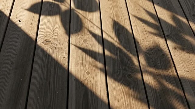 Dynamic leaf shadows dance across weathered wooden planks creating a serene, natural atmosphere.