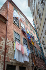 Colorful loundry drying on lines outside old stone buildings in a narrow street, capturing everyday life and traditional urban atmosphere