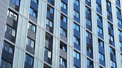 Fototapeta premium Modern residential building facade with glass windows and colorful panels, urban architecture background 