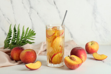 Napkin and glass of tasty peach iced tea on marble background, closeup