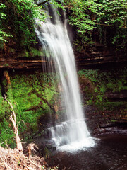 Obraz premium The 15m-high Glencar Waterfall, Ireland. Popular tourist attraction and point of interest. Nobody. Beautiful Irish nature concept.