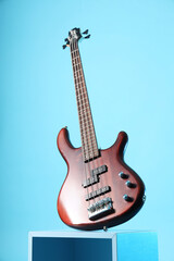 Decorative podium with modern electric guitar on blue background