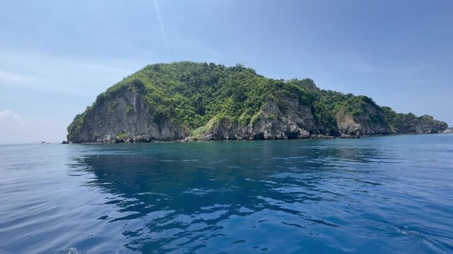 Scenic boat ride around Apo Island, a famous diving and snorkeling destination in the Philippines with turquoise waters and lush tropical coastline.