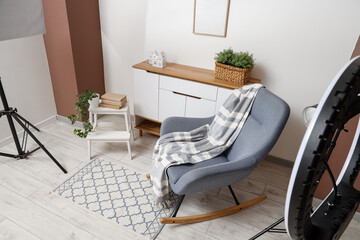 Photo shoot of living room with rocking armchair, commode and stool in studio