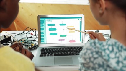 Laptop display coding system while student studying writing engineering code. Back view of diverse student learning programming system while pointing at screen at STEM technology class. Edification - Powered by Adobe