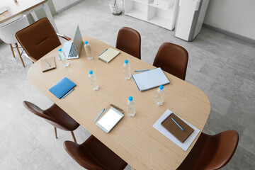 Naklejka premium Modern conference room table with laptops tablets notepads and water bottles for business meetings and corporate training