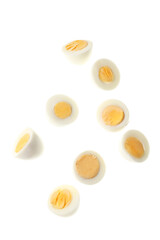 Flying halves of boiled chicken eggs on white background