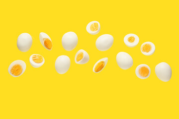 Flying many boiled chicken eggs on yellow background