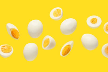 Flying boiled chicken eggs on yellow background