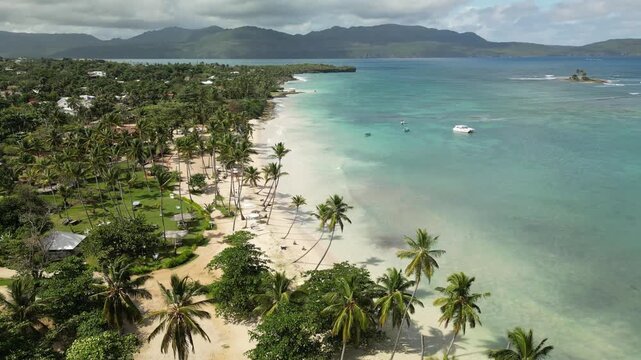 Aerial 4K view of Playa Las Galeras &mdash; tropical beach with palms, long shadows, and ocean in warm afternoon light. Filmed 23 August 2025, Las Galeras, Dominican Republic