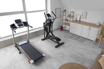 Interior of living room with treadmill and elliptical machine
