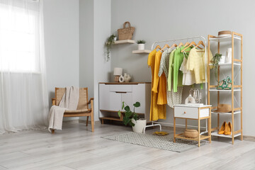 Interior of dressing room with clothes rack, armchair and commode