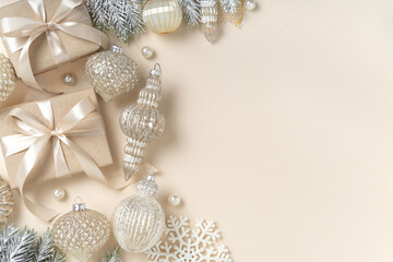 Luxury Christmas decorations with elegant gifts, stylish ornaments on beige background with copy space.	