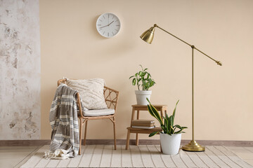 Interior of living room with wall clock, armchair and lamp