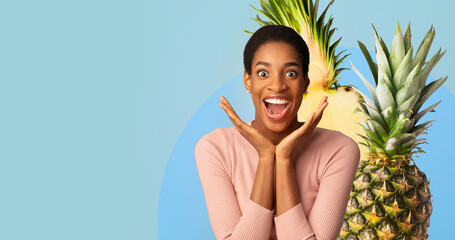 A joyful person showcases a collage of fruits, celebrating the benefits of vitamins and nutrition....