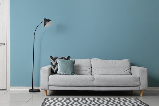 Black lamp and sofa near green wall in living room