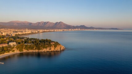 Fototapeta premium Aerial View of Coastal City with Mountains in the Background at Sunrise