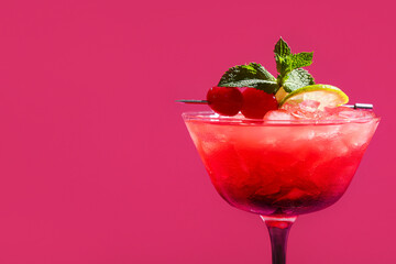Glass of tasty Mai Tai cocktail garnished with cherries and lime on pink background