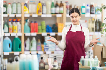 Female saleswoman friendly invites to shop in the household department of a supermarket. Best...