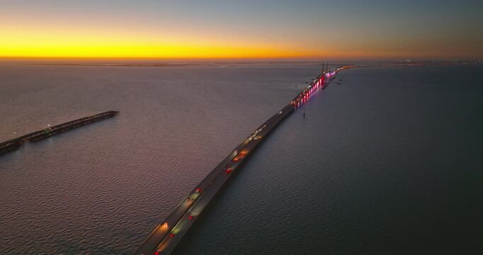 Highway road traffic driving at sundown over Sunshine Skyway Bridge in Florida. Transportation infrastructure in USA