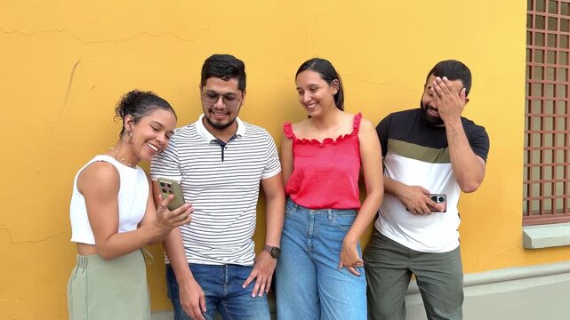 Three friends, two women and a man, are enjoying some lighthearted content on a smartphone, laughing and sharing a moment of amusement