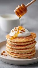 Delicious stack of oat pancakes with yogurt, nuts, and honey drizzle for breakfast inspiration