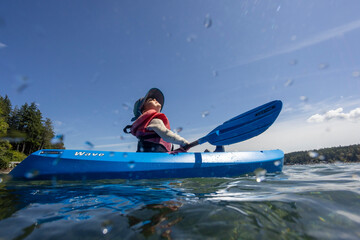A young toddler enjoys a kayak in the ocean off the coast of Washington State.