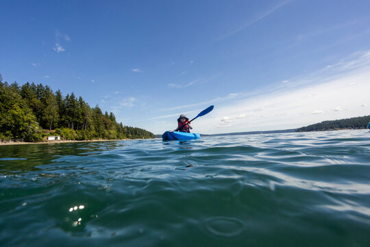 A young toddler enjoys a kayak in the ocean off the coast of Washington State.