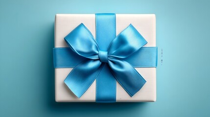 Surprise gift wrapped in white paper and a light blue ribbon on a solid blue background ready for celebration
