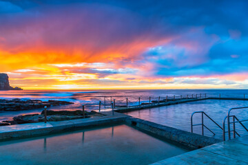 Winter sunrise by the sea pool with rain clouds