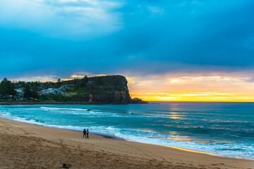 Winter sunrise by the sea shore with rain clouds