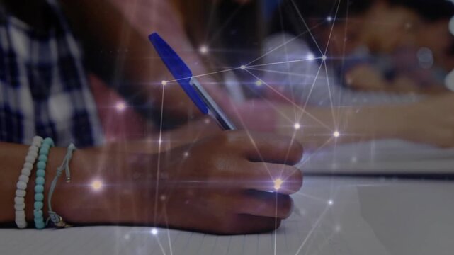 Student hand contacting grid paper and activating network overlay while taking notes in classroom