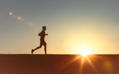 Silhouetted Runner During Sunrise on Scenic Outdoor Landscape
