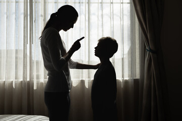 parent firmly correcting their child near a window, concept of discipline, parenting, family...