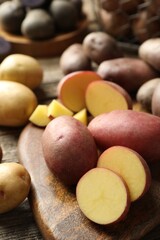 Different types of potatoes on wooden table, closeup