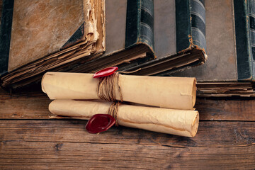 Old rolled paper scrolls and book on wooden table