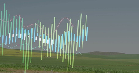 Fototapeta premium Floating translucent financial chart over rural hills and line graphs, with colorful candlesticks