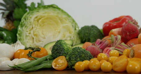 Presenting assorted fresh vegetables on wooden countertop, with cabbage half, broccoli florets