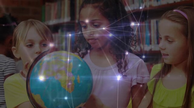 Students exploring globe in library with center student turning it activating network overlay