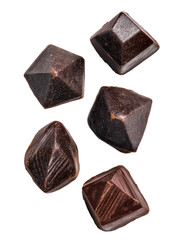 Dark chocolate pyramids,  isolated.  Five pyramid-shaped, dark chocolate treats,  angled,  falling,  on black background.  Visually appealing