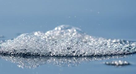 A close-up view of a frothy, light-blue soap suds, showcasing a multitude of small, glistening bubbles.
