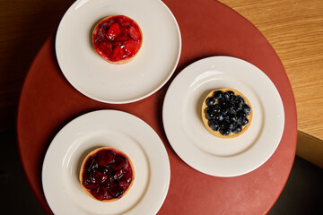 Savor the Deliciously Beautiful Fruit Tarts with Fresh Berries Presented on Elegant Plates