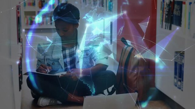 Student opening notebook and writing in library, checking laptop and creating digital globe graphic