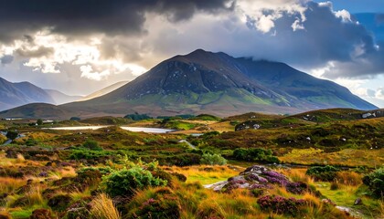 Fototapeta premium A breathtaking landscape showcases rolling hills, a serene lake, and majestic mountains under a dramatic sky.