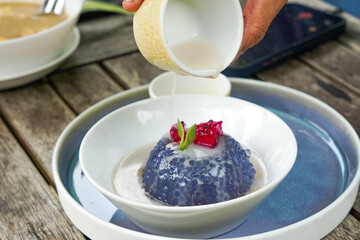 Kuih Sagu Melaka Bunga Telang, a traditional Malaysian dessert made with blue butterfly pea-infused tapioca pearls, served with palm sugar syrup and coconut milk.