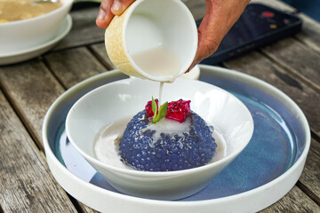 Kuih Sagu Melaka Bunga Telang, a traditional Malaysian dessert made with blue butterfly pea-infused tapioca pearls, served with palm sugar syrup and coconut milk.