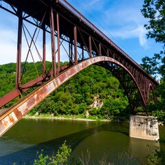 Obraz premium Rusty steel arch bridge over a river