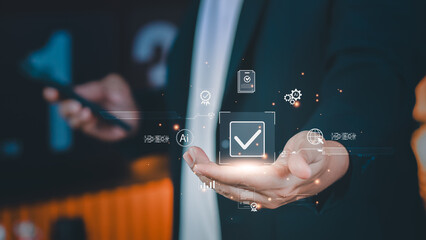 Concept of AI-enabled quality control and compliance verification as a businessman presents a floating digital check mark, symbolizing approval workflow, standard assurance, and efficient processes.