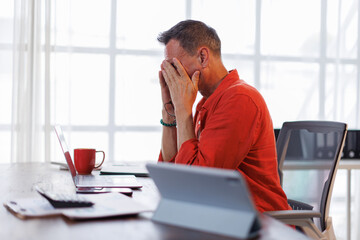 Worried mature professional business man reading bad news in document at work. Tired upset busy 50s middle aged business man feeling stress looking at paper bill having problem in office.
