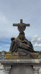 Obraz premium A Pietà statue on a tomb in a cemetery